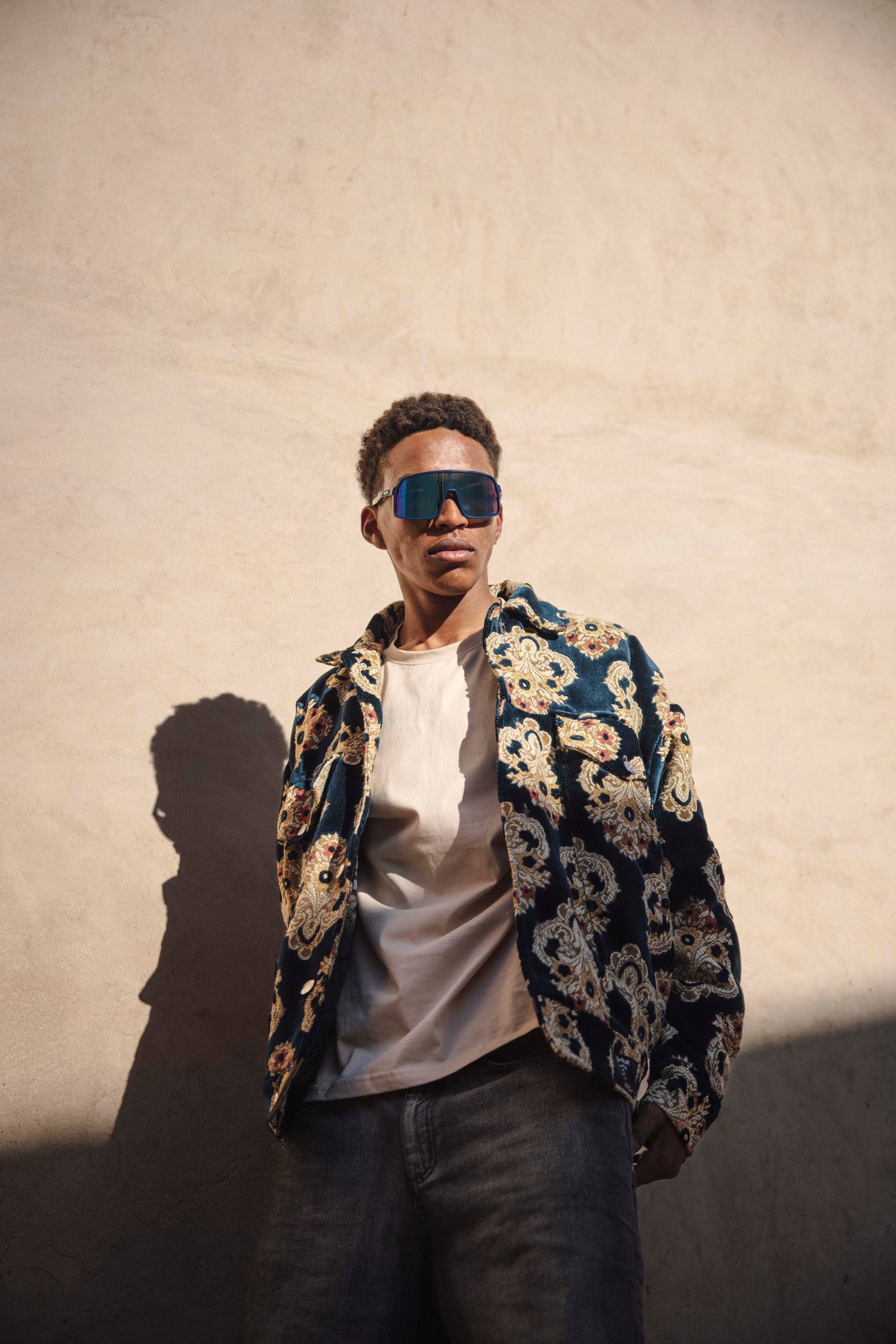 Model in sunglasses and an embroidered jacket in late sunlight