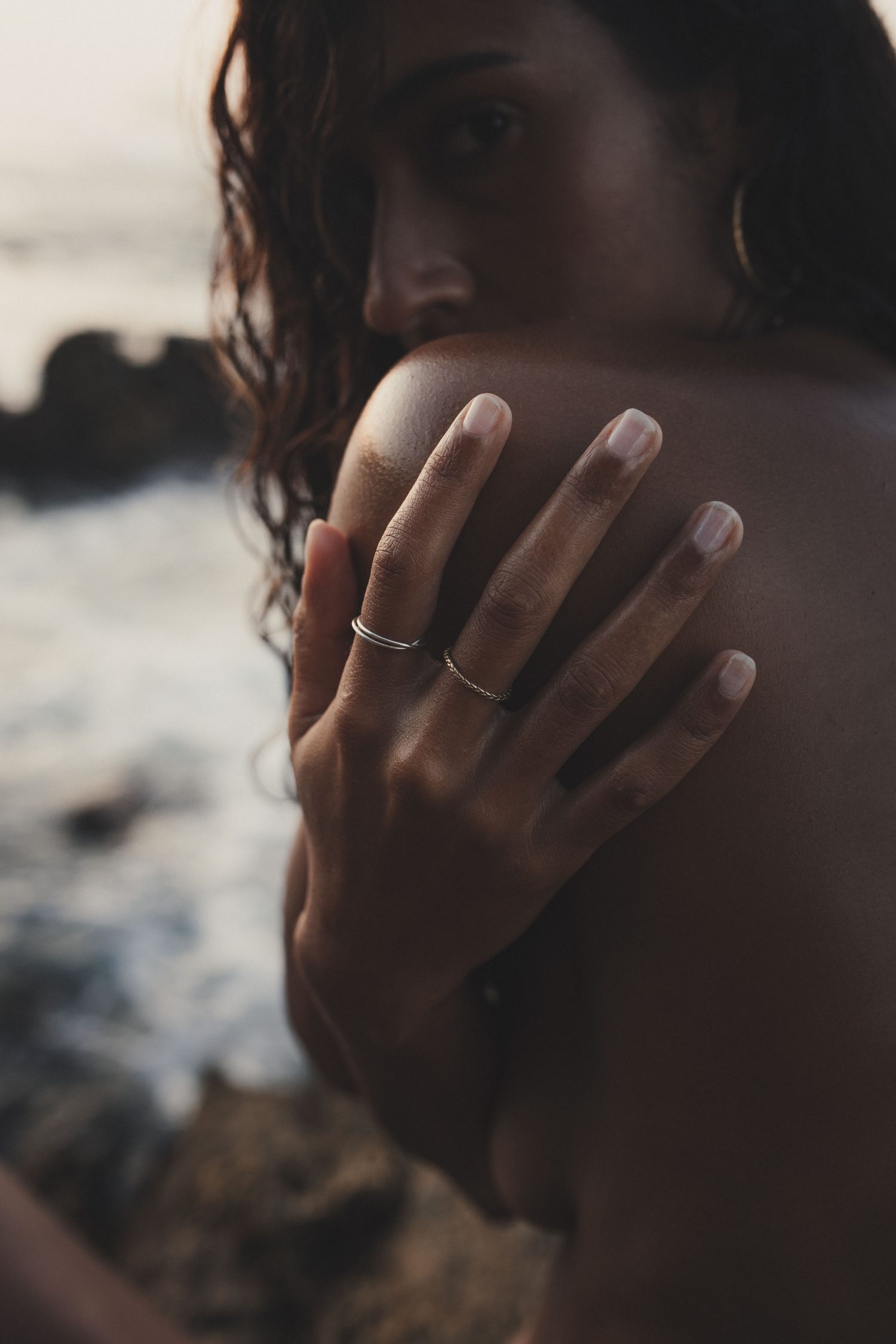 Hand with fine rings resting on the shoulder