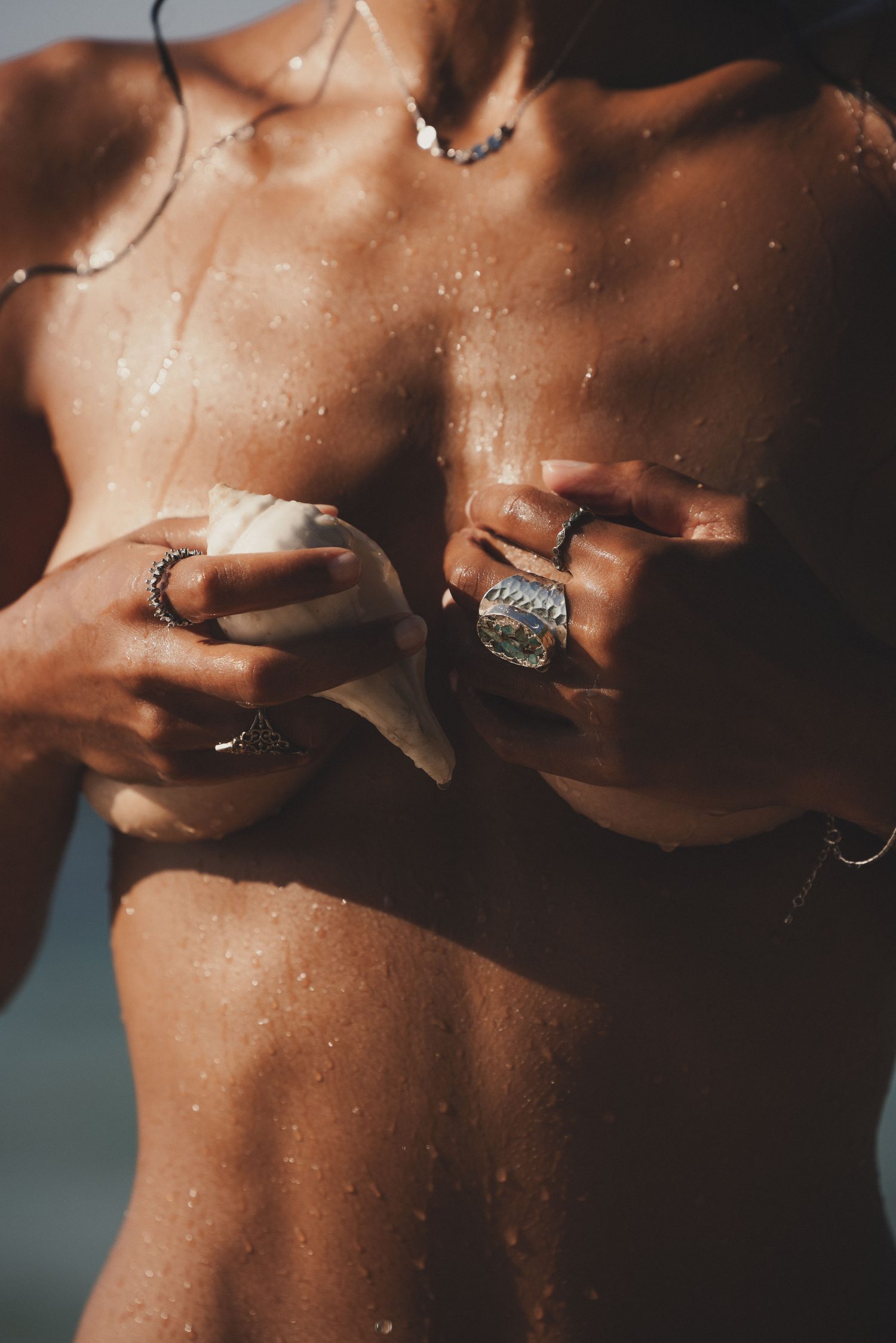 Hands with rings and a shell, close-up