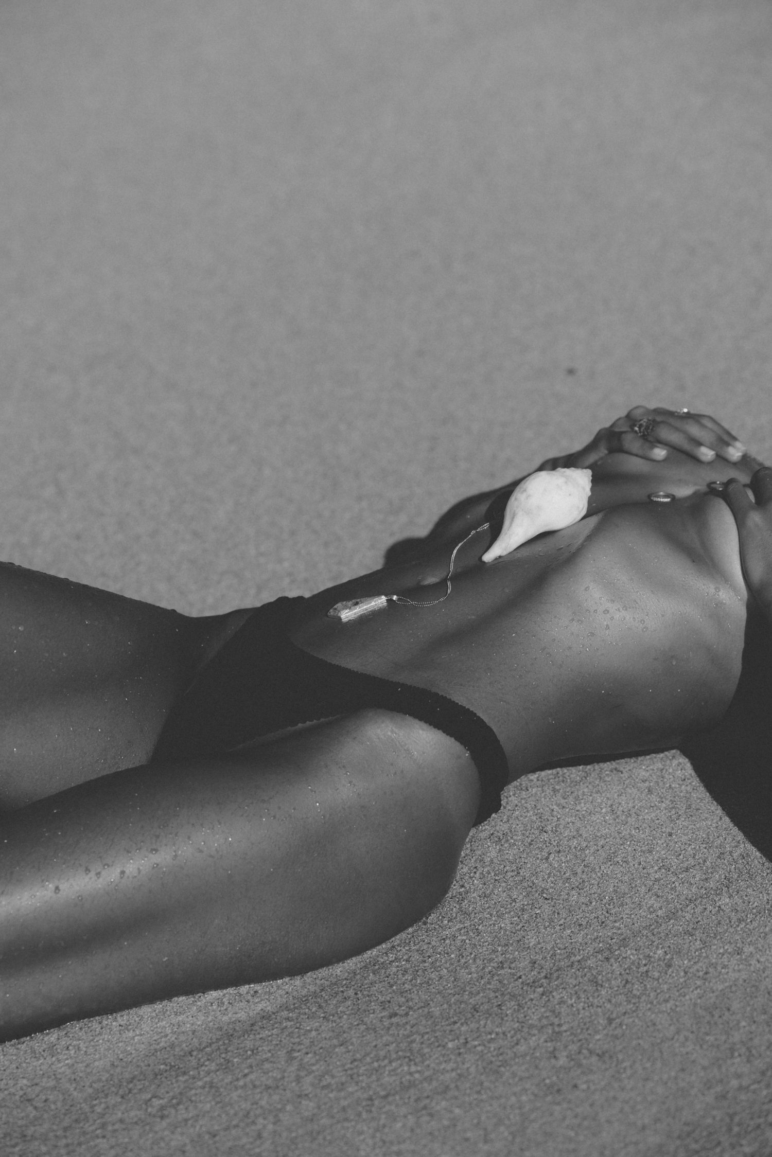Hand with a shell resting on the body, in black and white