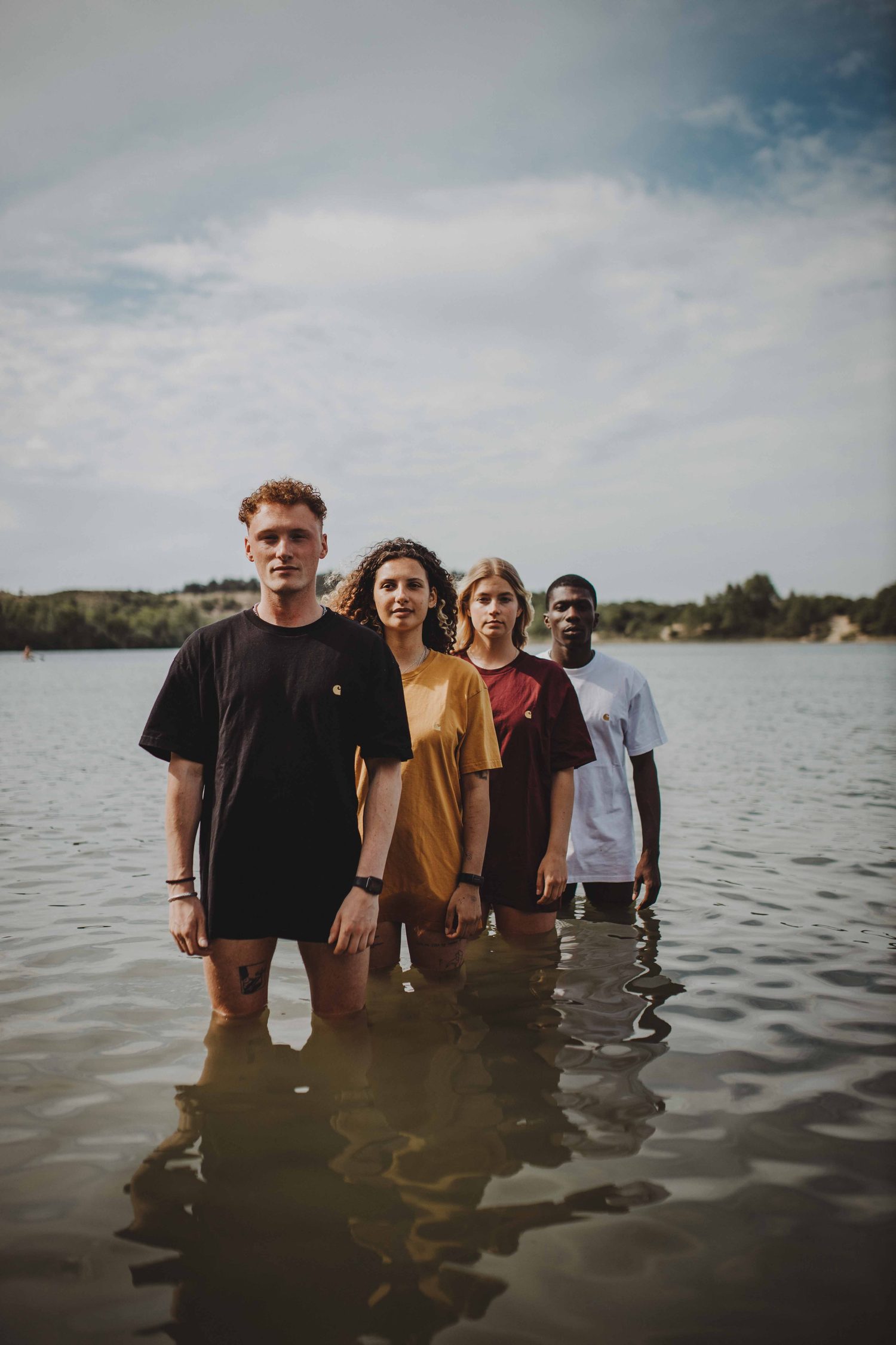 Four models in Carhartt T-shirts standing knee-deep in the water