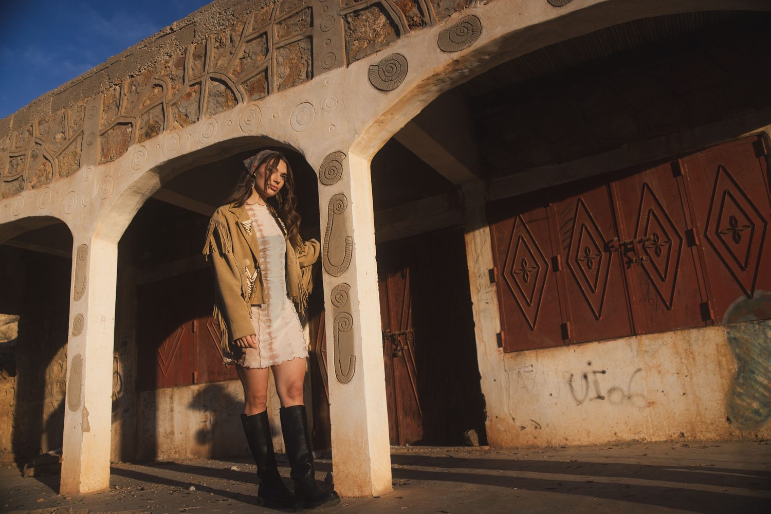 Woman standing in a row of white concrete arches